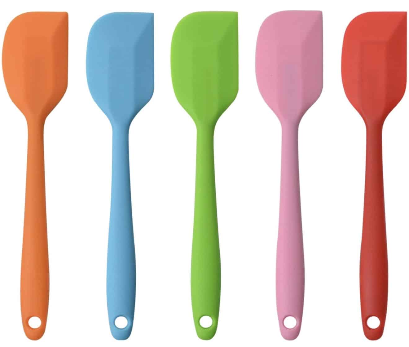 Five silicone spatulas in a row, each flaunting a vibrant Valentine’s Day hue: orange, blue, green, pink, and red. With matching handles featuring handy holes, they stand vertically and are perfect for crafting festive Rice Krispie Treats.